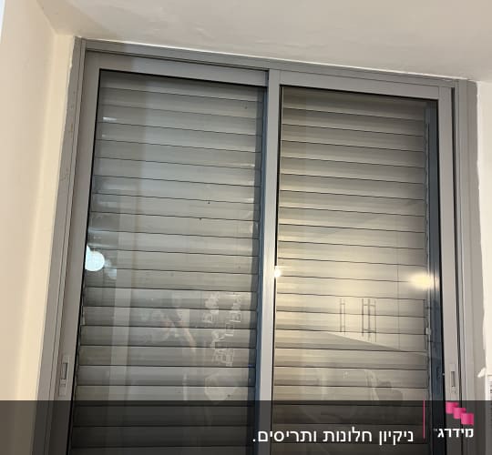 חלון עם תריסים סגורים בחדר פנימי